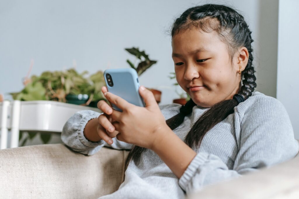 Concentrated asian girl looking at smartphone