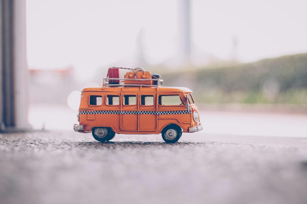 Orange van die cast model on pavement